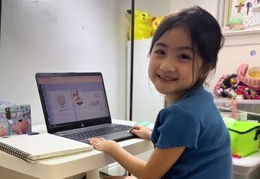 An Insight PA student is sitting at their home work space. They have a notebook and an open laptop on their desk