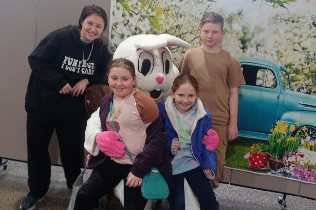 An Insight PA parent and three children are posing with the Easter Bunny. Two children are sitting on the bunny’s lap.
