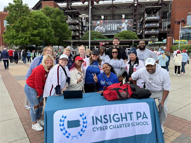 Insight PA staff members smiling at a table outside of a Phillies Game.
