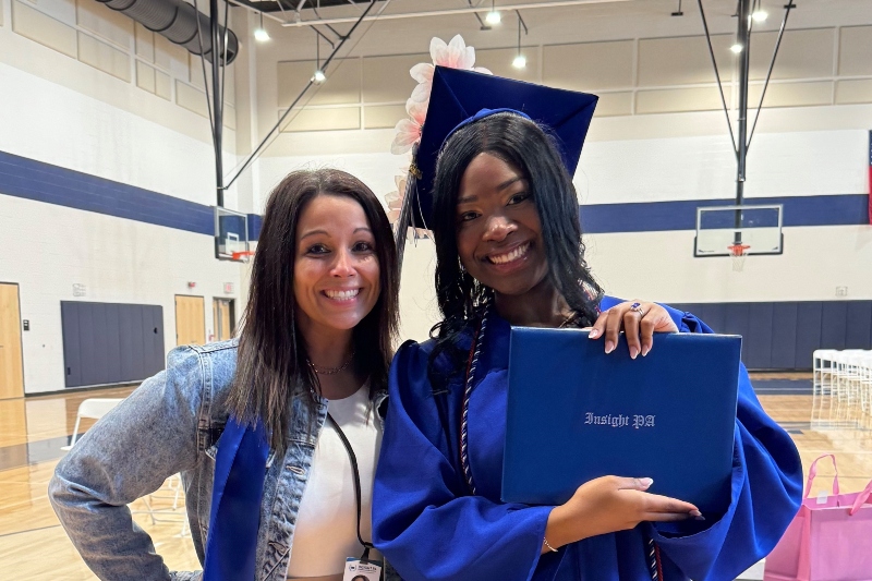 An Insight PA graduate poses at graduation with an Insight PA staff member.
