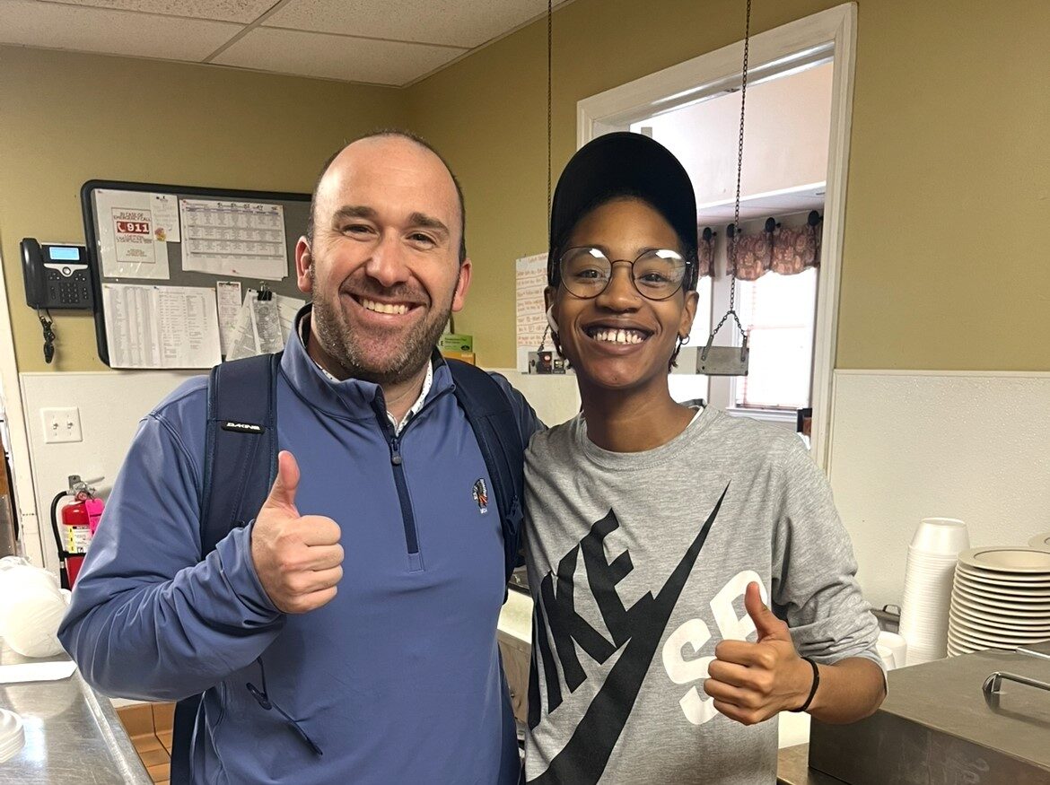 A teacher gives a thumbs up sign